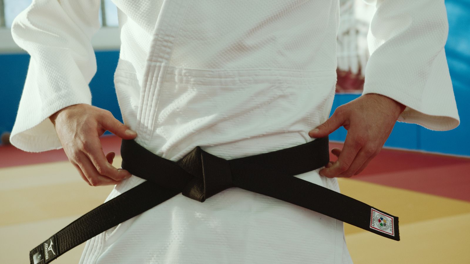 A martial artist tying a black belt